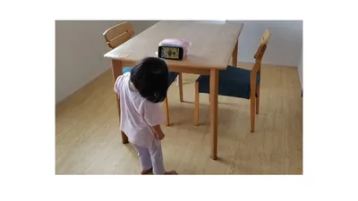 テーブルに置いたスマホで動画を見る娘。見る場所と時間を決めています