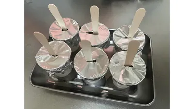 紙コップにアルミホイルをかぶせ、切れ込みから木製スプーンを差した状態。このまま冷凍庫へ
