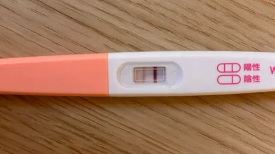 妊娠検査薬の判定結果を示した実際の写真。陽性を示す「判定線」と判定終了を示す「終了線」の2本があるが、判定線が終了線に比べかなり薄い。