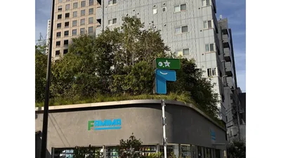 緑に囲まれた外観。大きなファミマのロゴのオブジェが目印です