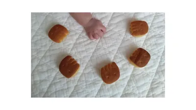 手の形のビスケットを並べたところへ、赤ちゃんが手を伸ばす様子