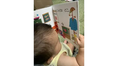 絵本を手に取り、口に入れて確かめる赤ちゃん。この時期ならではの姿です
