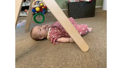 ベビージムの下で遊んでいる場面