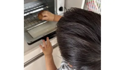 使用前のトースターにパンを入れるところ。大人がそばで見守ります