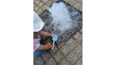 公園の水遊び場で挑戦。仕組みを理解すると、自分で水に入れて棒を引っ張っていました